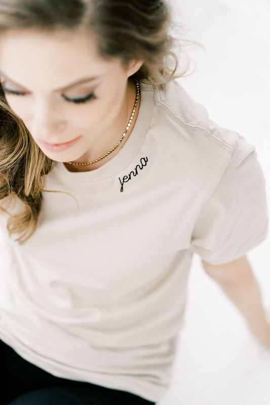 sand color tshirt embroidered with name along the collar